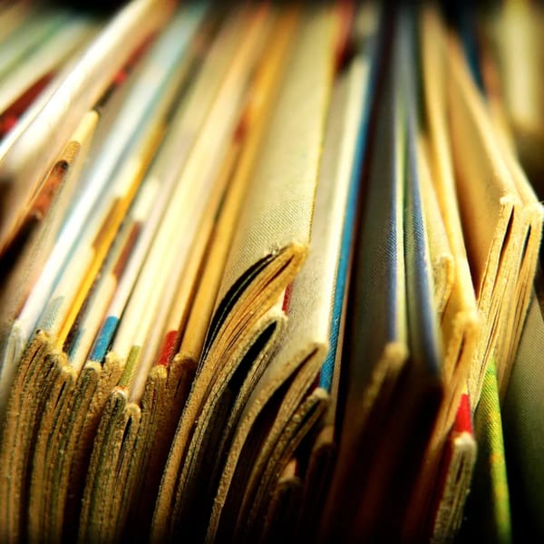 Close-up of many comic books or magazines standing upright, showing their worn pages and colorful spines.