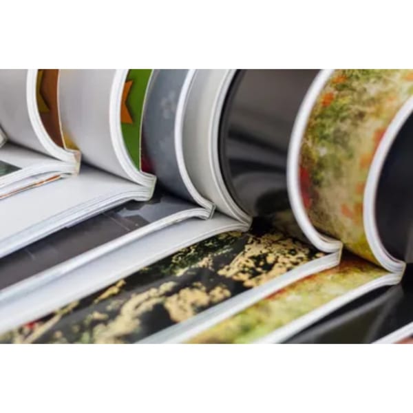 Close-up of several comic books and magazines with colorful covers, stacked and fanned out.