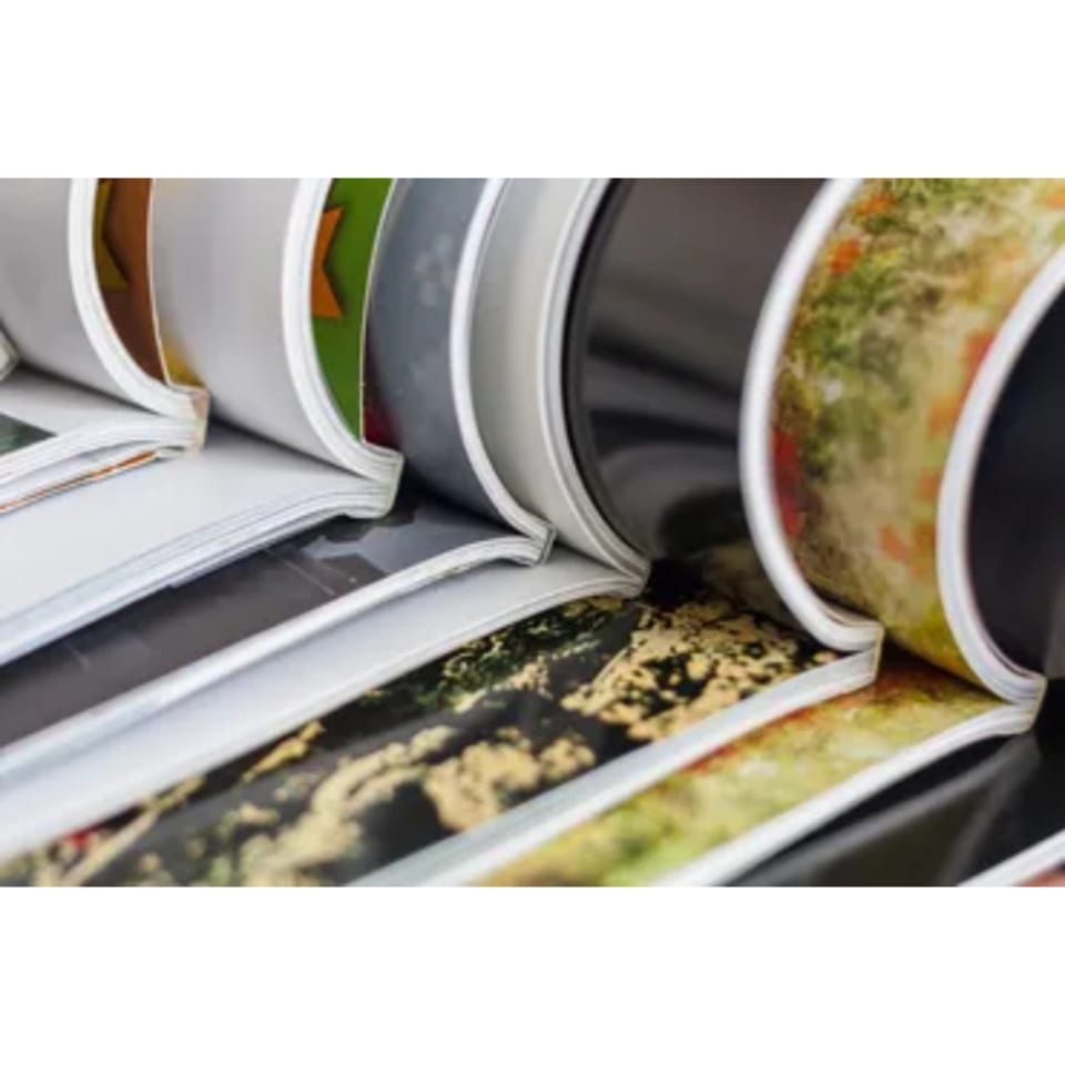 Close-up of several comic books and magazines with colorful covers, stacked and fanned out.